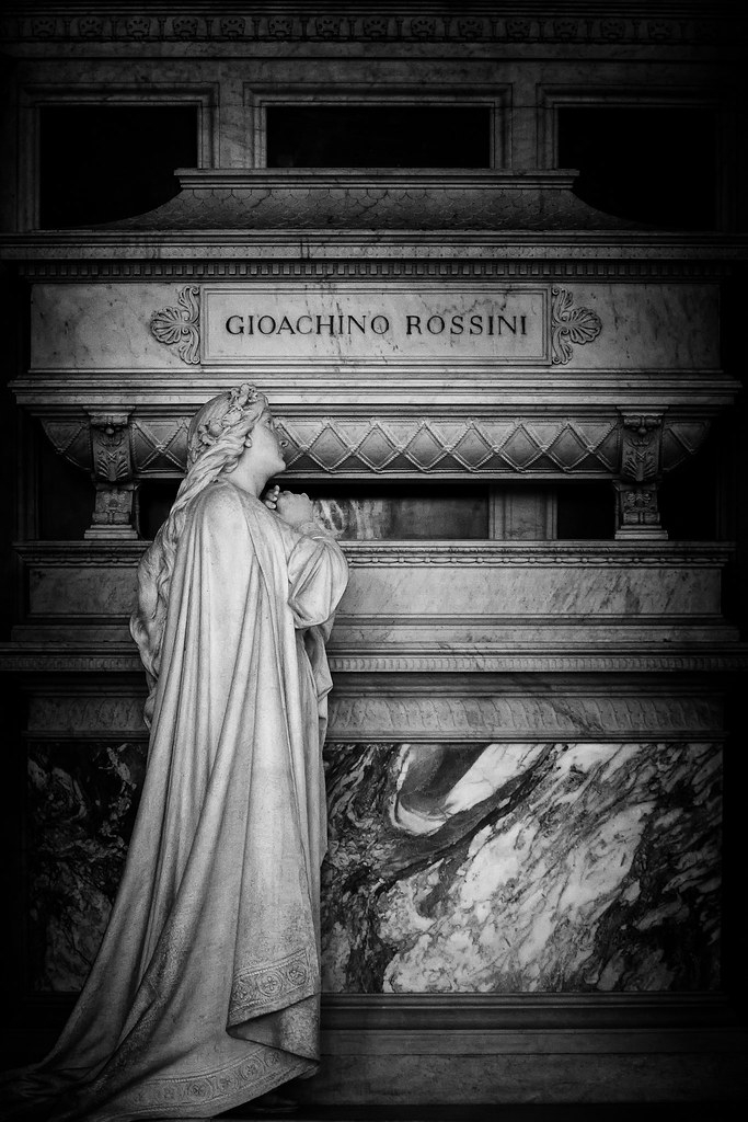 Zwart-witfoto van het grafmonument van Gioachino Rossini in de basiliek Santa Croce in Florence, met een rouwende vrouwengestalte in marmer